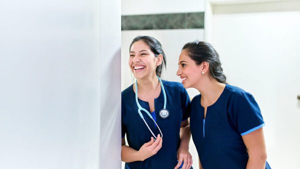 Healthcare: Happy female medical doctors in a hospital. Young medical hospital professionals, happy in healthcare facility. Copy space for text